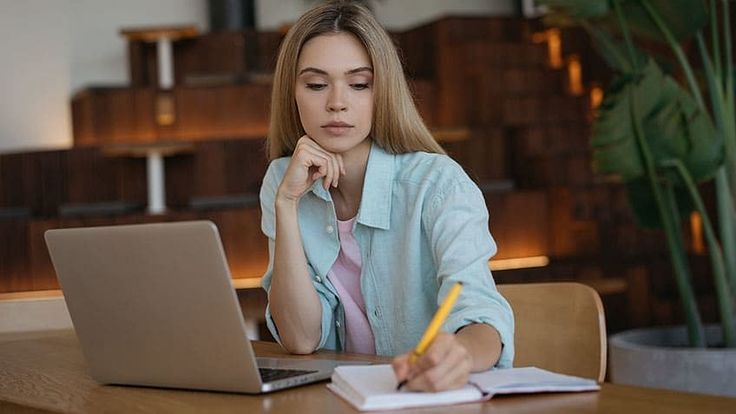 Ilustrasi karyawan sedang belajar skill baru dengan laptop dan catatan, menunjukkan semangat pengembangan diri di tempat kerja.