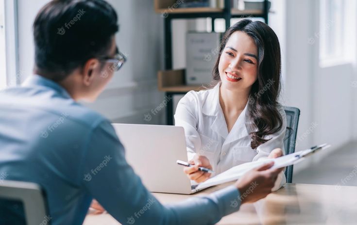 Ilustrasi dua rekan kerja sedang berdiskusi dengan ekspresi serius namun santai, mencerminkan komunikasi efektif di tempat kerja.