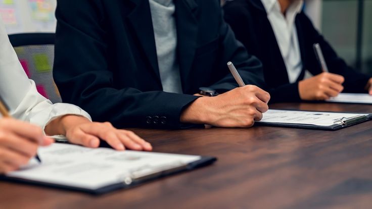 Peserta sedang mengisi formulir saat mengikuti uji sertifikasi BNSP, mengenakan pakaian formal di ruang ujian resmi.